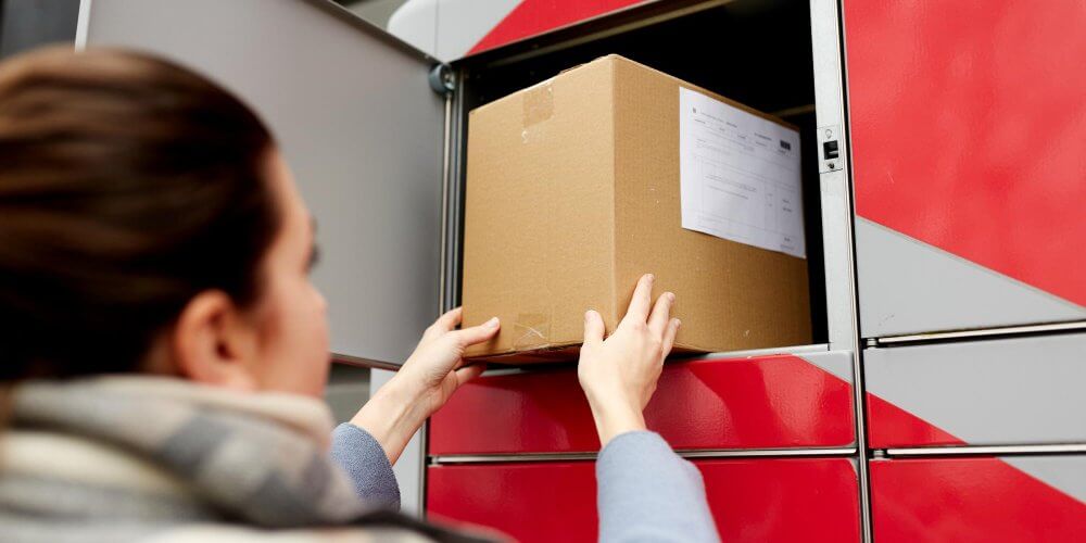 Kobieta nadająca paczkę w automacie paczkowym