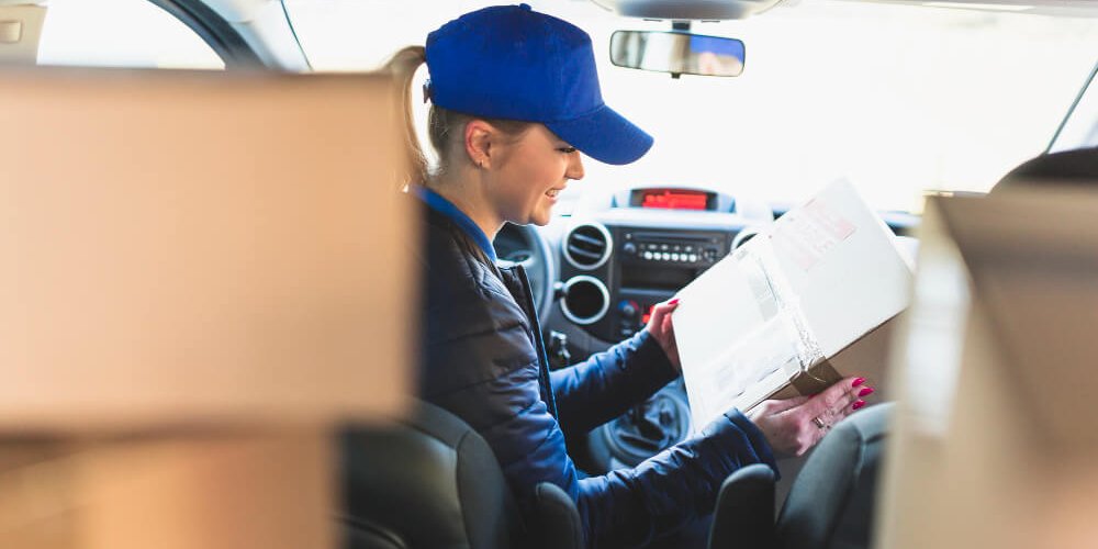 Kurierka z paczkami w samochodzie