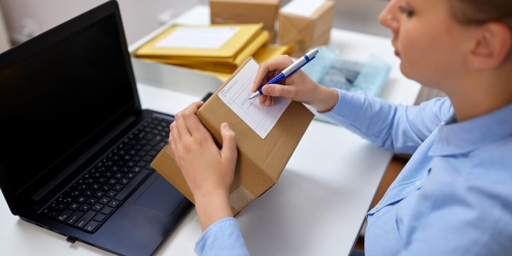 Kobieta nadająca paczkę w punkcie kurierskim