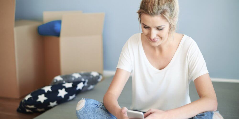 Kobieta śledząca przesyłkę kurierską w telefonie