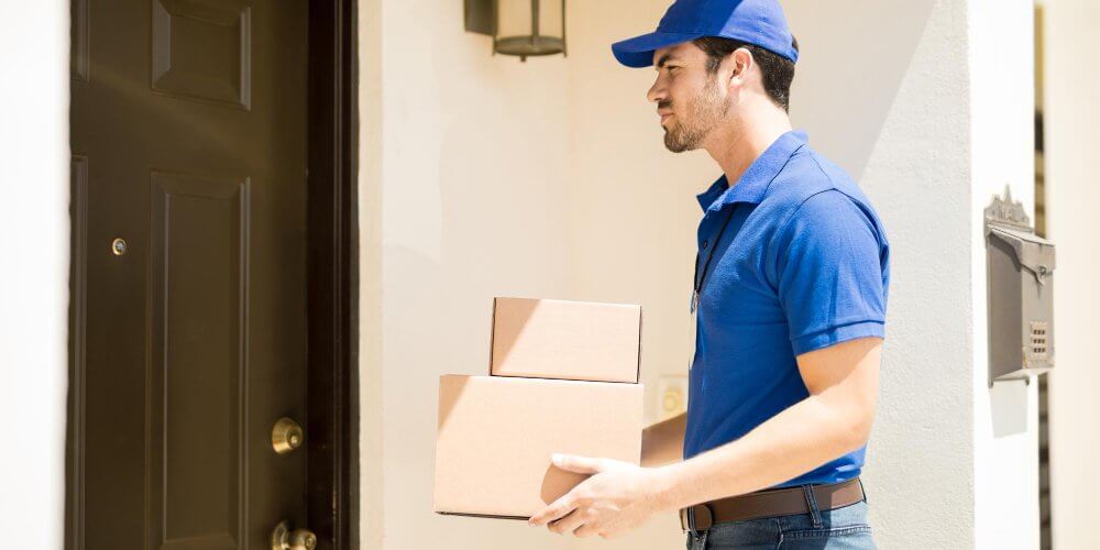 Kurier czekający pod drzwiami z przesyłką