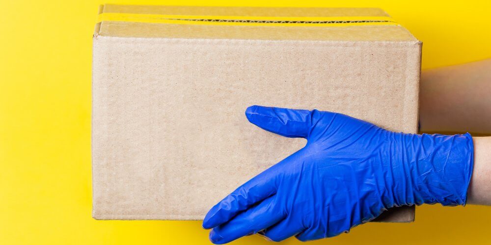 Kurier dostarczający przesyłkę medyczną w rękawiczkach