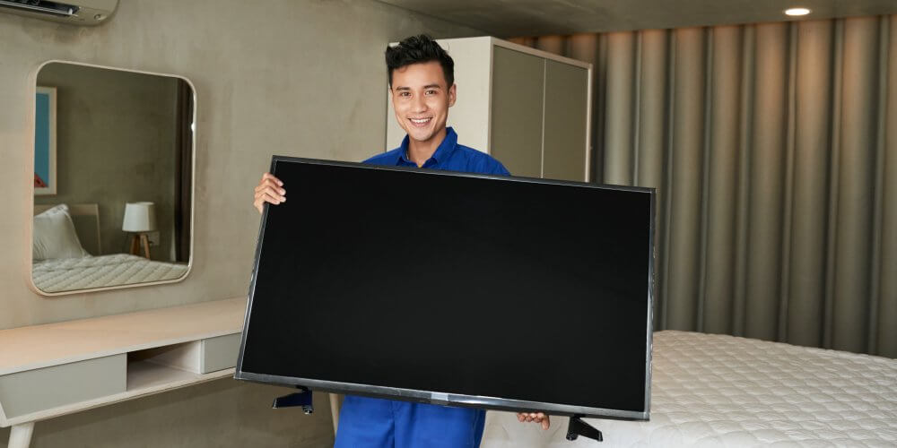 Mężczyzna przenoszący telewizor