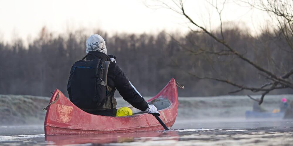 Mężczyzna wiosłujący na kajaku