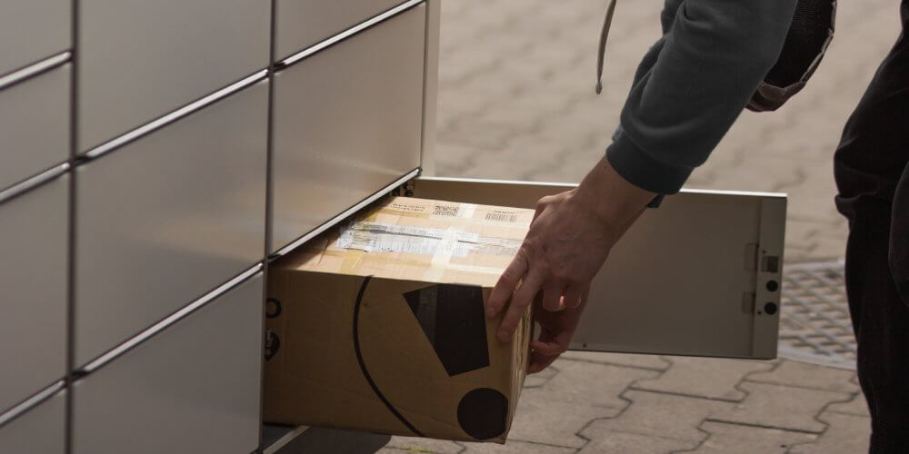 Mężczyzna wysyłający przesyłkę w automacie paczkowym