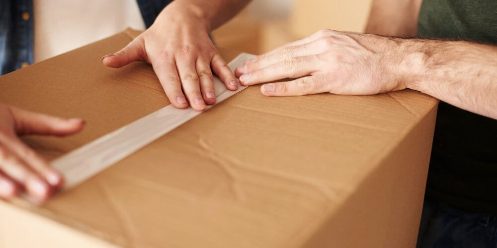 Para pakująca przesyłkę kurierską