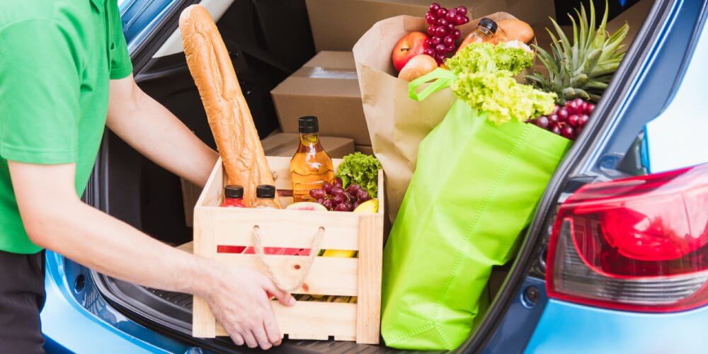 przesyłki żywności w bagażniku samochodu kuriera